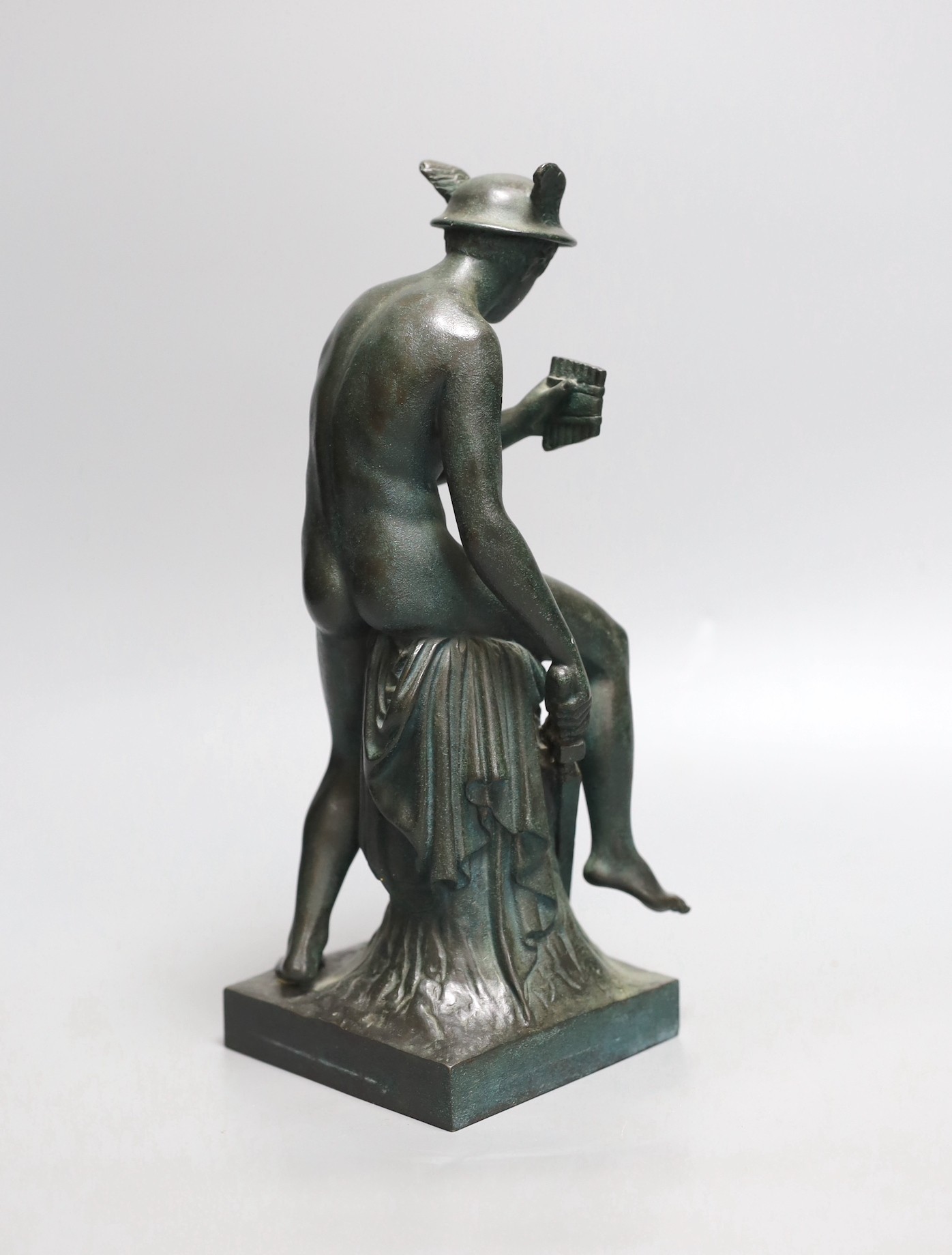 After the antique, a bronze figure of a seated Hermes playing the pan flute, 26cm